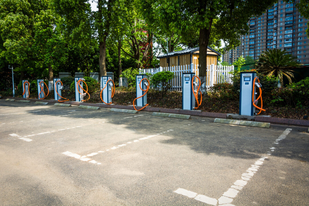 Coches eléctricos aparcados y conectados a puntos de recarga en un garaje comunitario
